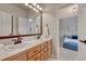 Bathroom featuring double sinks and vanity with wood cabinets at 581 Stonemont Dr, Castle Pines, CO 80108