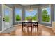 Bright breakfast nook featuring a wood table, hardwood floors and large windows with serene, green outdoor views at 581 Stonemont Dr, Castle Pines, CO 80108