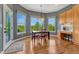 Bright breakfast nook featuring a wood table, hardwood floors and large windows with serene, green outdoor views at 581 Stonemont Dr, Castle Pines, CO 80108