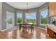 Bright breakfast nook featuring a wood table, hardwood floors and large windows with serene, green outdoor views at 581 Stonemont Dr, Castle Pines, CO 80108