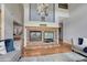 Cozy living room featuring a brick fireplace, hardwood floors, and comfortable seating at 581 Stonemont Dr, Castle Pines, CO 80108