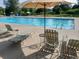 Community pool surrounded by lounge chairs and umbrellas at 581 Stonemont Dr, Castle Pines, CO 80108
