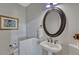 Small powder room featuring an oval mirror, pedestal sink, and artwork on light gray walls at 581 Stonemont Dr, Castle Pines, CO 80108