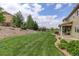 Lush backyard with a well-maintained lawn and mature trees, creating a serene outdoor space for recreation and enjoyment at 23451 E Rockinghorse Pkwy, Aurora, CO 80016