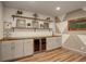 Elegant bar area with open shelves, wine fridge, and attractive decorative elements, perfect for entertaining guests at 23451 E Rockinghorse Pkwy, Aurora, CO 80016