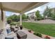 Cozy covered patio with comfortable seating and views of the landscaped backyard, ideal for relaxation and entertainment at 23451 E Rockinghorse Pkwy, Aurora, CO 80016