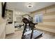 Well-equipped exercise room with a treadmill, weight machine, and a large mirror, promoting a healthy lifestyle at 23451 E Rockinghorse Pkwy, Aurora, CO 80016