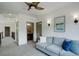 Upstairs hall with gray couch and access to a full bathroom with wood vanity at 23451 E Rockinghorse Pkwy, Aurora, CO 80016