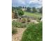 Lush backyard garden with a mix of greenery, gravel paths, and fencing overlooking a green space at 11879 W Portland Dr, Littleton, CO 80127