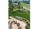 Serene backyard featuring a stone patio with a fire pit, lush lawn, and a picturesque tree line at 11879 W Portland Dr, Littleton, CO 80127