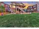 Large grassy backyard with stone accents, covered patio, upper deck with stairs for outdoor living at 11879 W Portland Dr, Littleton, CO 80127