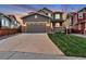 Charming two-story home boasts a manicured lawn, brick accents, and an attached two-car garage at 11879 W Portland Dr, Littleton, CO 80127