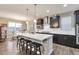 Modern kitchen featuring dark cabinets, a large island with seating, pendant lighting, and stainless steel appliances at 11879 W Portland Dr, Littleton, CO 80127