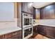 Well-equipped kitchen featuring stainless steel double ovens, white countertops, subway tile backsplash, and ample cabinetry at 11879 W Portland Dr, Littleton, CO 80127