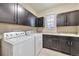 Well-lit laundry room with modern washer, dryer, cabinetry, and a convenient utility sink at 11879 W Portland Dr, Littleton, CO 80127