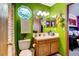 Bright, green bathroom features a unique octagon window and oak vanity at 2213 Emery St # C, Longmont, CO 80501