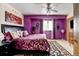 Main bedroom showcasing stylish purple accent wall, ceiling fan, and ample natural light at 2213 Emery St # C, Longmont, CO 80501