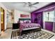 Bright main bedroom with large bed, ceiling fan, and a unique purple accent wall at 2213 Emery St # C, Longmont, CO 80501