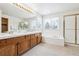 Bright bathroom featuring double sinks, tub, and a glass-enclosed shower, providing a luxurious experience at 9928 Candlewood Ct, Highlands Ranch, CO 80126