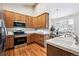 Spacious kitchen with wood cabinets, stainless steel appliances, and a tiled backsplash at 9928 Candlewood Ct, Highlands Ranch, CO 80126