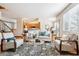 Bright living room boasts hardwood floors and a stylish seating arrangement with a view into the kitchen at 9928 Candlewood Ct, Highlands Ranch, CO 80126