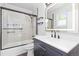 Modern bathroom featuring a glass enclosed shower, vanity, and a well-lit mirror at 8367 S Reed St # A3, Littleton, CO 80128