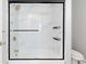 Modern bathroom with black trim shower and toilet with tile and glass surround at 8367 S Reed St # A3, Littleton, CO 80128