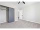 Bright bedroom featuring a ceiling fan, carpet, and closet with sliding doors at 8367 S Reed St # A3, Littleton, CO 80128