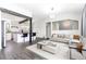 Bright, open-concept living room featuring modern decor, hardwood floors, and seamlessly connected kitchen with bar seating at 8367 S Reed St # A3, Littleton, CO 80128