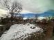 View of the backyard with a wooden fence partially covered in snow at 1170 W 135Th Dr, Denver, CO 80234