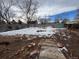 Wide backyard space mostly covered in snow with patches of dry ground and dead foliage at 1170 W 135Th Dr, Denver, CO 80234