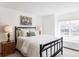 Comfortable bedroom features an iron frame bed, window, and bedside lamps at 9257 Shadowglen Ct, Highlands Ranch, CO 80126