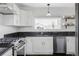 Modern kitchen featuring white cabinets, granite countertops, stainless steel appliances, and a window at 9257 Shadowglen Ct, Highlands Ranch, CO 80126