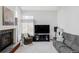 Comfortable living room with fireplace, large windows, TV, sofa, and a comfortable armchair at 9257 Shadowglen Ct, Highlands Ranch, CO 80126