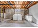 Unfinished basement laundry area with washer, dryer, and storage at 1912 S Truckee St, Aurora, CO 80013