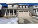 Two-story house with beige siding, attached garage, and snowy front yard at 24665 E 41St Ave, Aurora, CO 80019