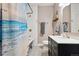 Well-lit bathroom showcasing shower/tub with curtain, updated vanity, and white tiled walls at 3429 N Adams St, Denver, CO 80205
