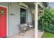 Inviting front porch with seating area, painted brick exterior, and bright red front door at 3429 N Adams St, Denver, CO 80205