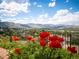 Scenic backyard view with vibrant red flowers and city skyline at 15895 W Bayaud Dr, Golden, CO 80401