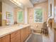 Clean bathroom with light wood cabinets and a window at 15895 W Bayaud Dr, Golden, CO 80401