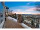 A wood plank deck and wrought iron railing look over the town with mountain views at 15895 W Bayaud Dr, Golden, CO 80401