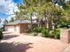 Exterior of brick home featuring a three car garage, mature trees, and a circular driveway at 15895 W Bayaud Dr, Golden, CO 80401