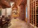 View of the wine cellar with stone walls, racks of wine, stained glass door and arched ceiling at 15895 W Bayaud Dr, Golden, CO 80401