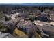 An aerial view of a suburban neighborhood showcases tree-lined streets, varied home styles, and distant mountain views at 9910 Winona St, Westminster, CO 80031