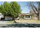 This single-story home features a well-kept lawn and mature trees, creating a serene and inviting outdoor space at 9910 Winona St, Westminster, CO 80031