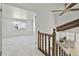 Hallway view showing bedroom and staircase with wood railing and kitchen with granite counters at 9910 Winona St, Westminster, CO 80031