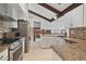 Bright kitchen featuring stainless steel appliances, granite countertops, white cabinets, mosaic backsplash and exposed beams at 9910 Winona St, Westminster, CO 80031