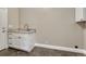 Functional laundry room equipped with a sink, cabinetry, and granite countertops at 46120 County Road 17, Elizabeth, CO 80107