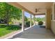 Covered back porch with ceiling fan, showcasing the lush, green backyard and nature at 3480 Spruce Dell Ct, Castle Rock, CO 80109