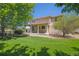 Back porch overlooks a green lawn with trees and a view to nature at 3480 Spruce Dell Ct, Castle Rock, CO 80109